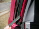 1994 Ford Bronco - A detached rubber seal is visible on the door frame of a red vehicle.
