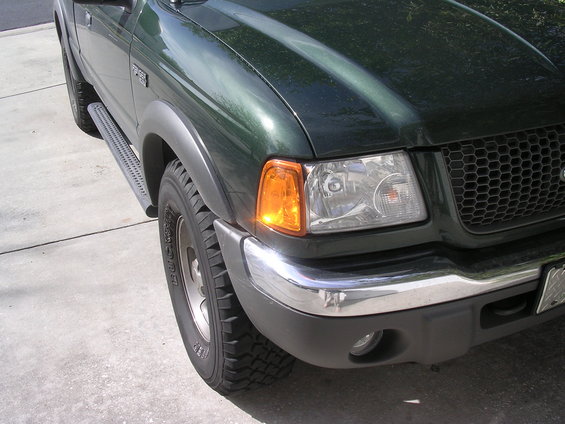 Green Ford Ranger pickup truck front corner with chrome bumper and honeycomb grille
