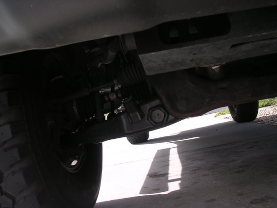 Underside view of a vehicle's front suspension and tire