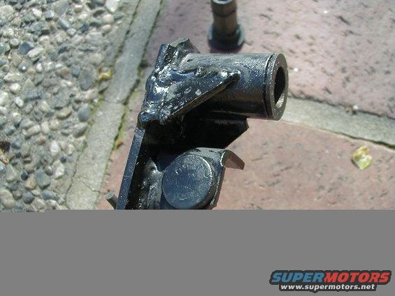 Close-up of a black metal automotive part with a cylindrical opening