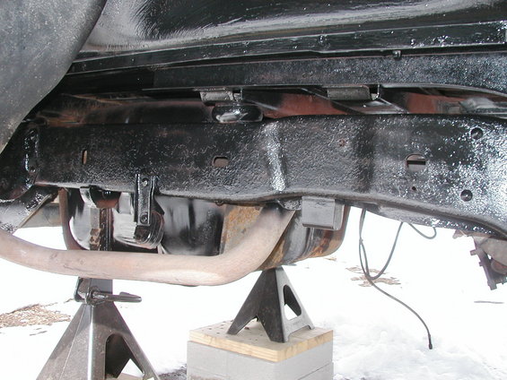 Black painted vehicle frame and exhaust pipe supported by jack stands