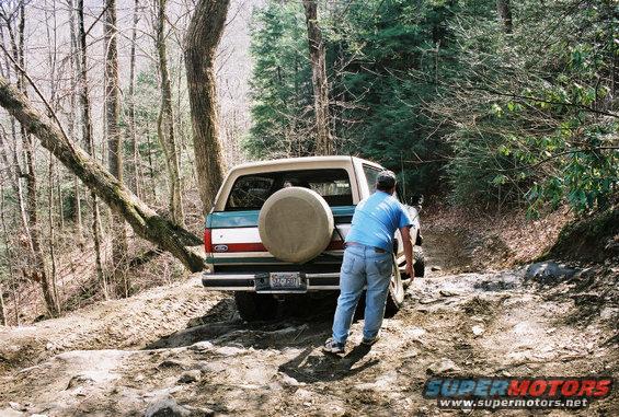 1990 Ford Bronco rear view with spare tire on dirt trail