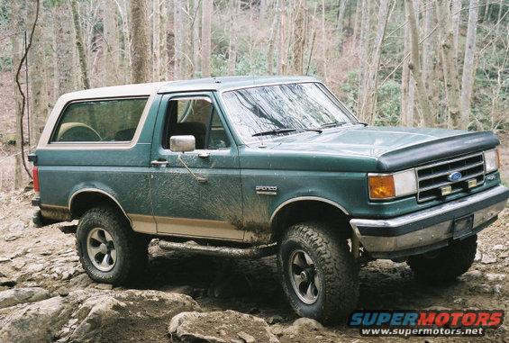 Green 1990 Ford Bronco on rocky terrain