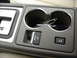 2002 Lincoln Town Car - The interior of a vehicle shows the center console, cupholders, a gear shifter, and an electronic parking brake button.