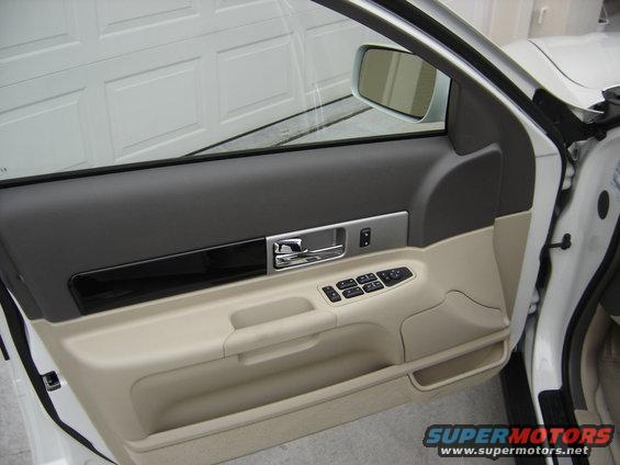 Interior door panel with chrome handle and window controls