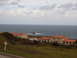 1988 Ford Bronco - Coastal buildings with orange roofs are situated on a hill above the sea.