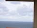 1988 Ford Bronco - A cloudy sky hangs over a choppy ocean, viewed from a balcony with a partial structure visible below.