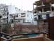 1988 Ford Bronco - A view from a balcony overlooks a courtyard with a pool, surrounded by buildings and an unfinished concrete structure.