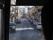 1988 Ford Bronco - A view down a street in a town, with cars parked on both sides and buildings lining the road.