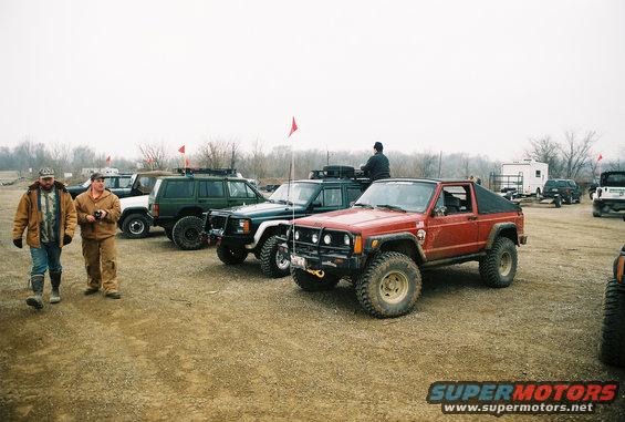 Red Jeep Cherokee Chief with aftermarket bumper and tires, parked outdoors