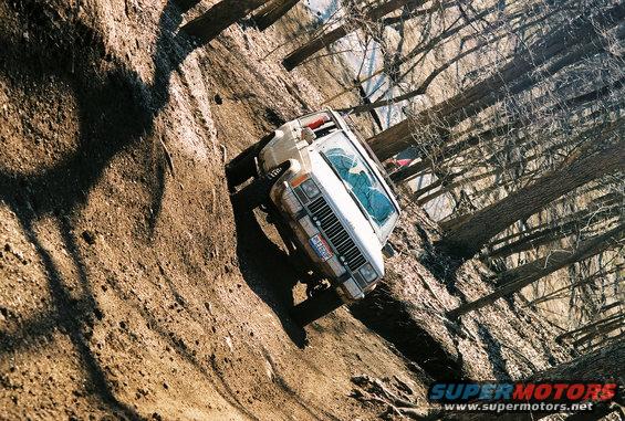 White Jeep Cherokee climbing steep muddy hill