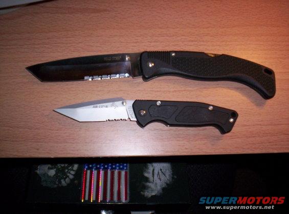 Two folding knives, one larger with serrated edge, and a smaller one with "AR-15" visible