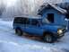 1994 Ford Ranger - A blue Ford Ranger pickup truck with a black camper shell sits in a snowy landscape next to a blue building.