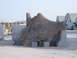 1988 Ford Bronco - A camouflaged structure is set up with concrete barriers and military buildings in the background.