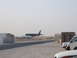 1988 Ford Bronco - A military jet is on the tarmac, with several vehicles parked in the foreground.