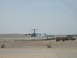1988 Ford Bronco - Two aircraft are visible on a dusty airfield, with barbed wire fencing in the foreground.