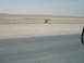 1988 Ford Bronco - A desolate desert scene barbed wire and anti-tank obstacles, with a road in the foreground.