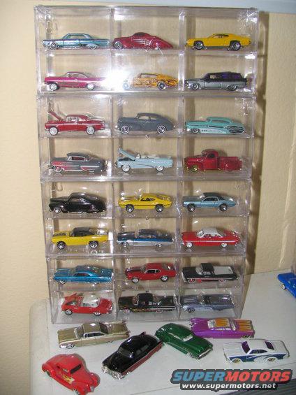 Display cases filled with various model cars, some loose on a shelf