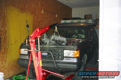 1989 Ford Bronco in garage with engine hoist attached, engine removed