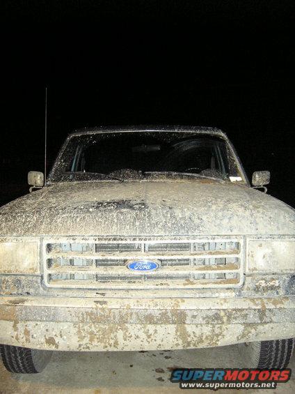 1989 Ford Bronco front end covered in mud, grille visible with Ford logo