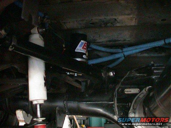 White shock absorber and black suspension components with blue hoses