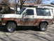 1986 Ford Bronco II - This weathered Ford Bronco II shows significant rust along its lower body panels.