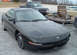 1994 Ford Probe - A black Ford Probe is parked in a lot with a pickup truck and other vehicles in the background.