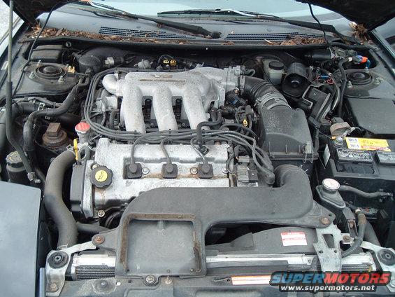 Engine bay with V6 intake manifold, battery, and radiator visible