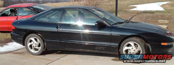 Black coupe with a GT badge on the side, seen from the side