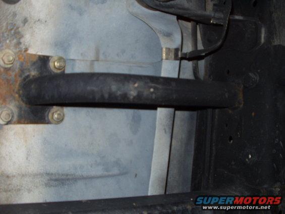 close-up of vehicle frame with hose and bolts
