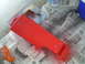 1994 Ford Bronco - Car door panel being painted red, laid out on newspapers with painting supplies.