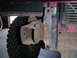 1994 Ford Bronco - This photo shows a close-up view of the front driver's side frame and tire of a vehicle, with a portion of the radiator visible.