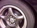 1997 Ford Probe - A close-up view of a vehicle's wheel and slotted brake rotor, with visible tire sidewall text.