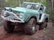 1969 Ford Bronco - This modified 1969 Ford Bronco navigates a wooded trail with aggressive off-road tires and a custom bumper.