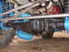 1969 Ford Bronco - Close-up view of a vehicle's differential housing and suspension components, partially covered by blue plastic.