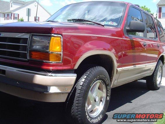 Red 1992 Ford Explorer SUV, front 3/4 view, tan lower body trim, chrome bumper, alloy wheels
