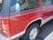 1992 Ford Explorer - The rear section of a red Ford Explorer SUV is shown, its distinctive taillight and two-tone trim.