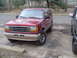 1992 Ford Explorer - A red 1992 Ford Explorer is parked in a lot, showing its front grille and side profile.