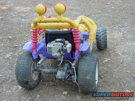 Purple go-kart with yellow roll cage and dual headlights, powered by a small engine