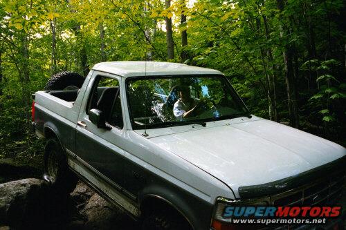 White and grey 1995 Ford Bronco on a wooded trail