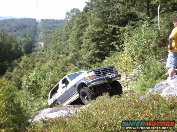 White and grey 1995 Ford Bronco off-roading on a rocky hill