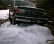 1988 Ford Bronco - Ford truck stuck in snow. Grille suggests a 1987-1991 model year.