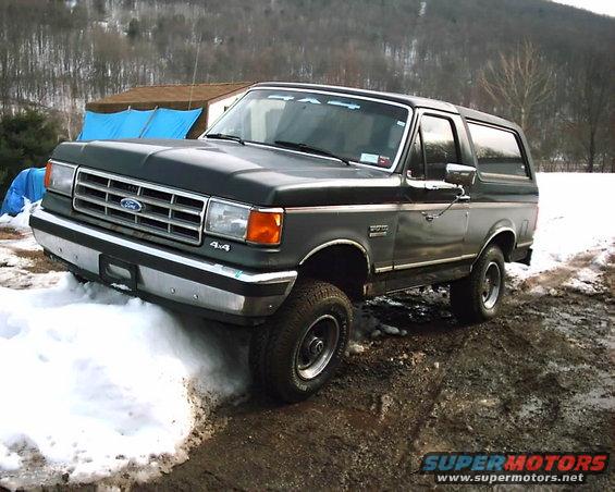 1988 Ford Bronco parked on a muddy, snowy track