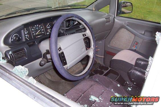 Interior of a van with broken glass on the dashboard and seats