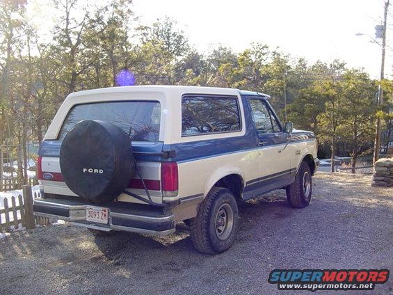 Two-tone blue and white 1989 Ford Bronco rear quarter view with spare tire