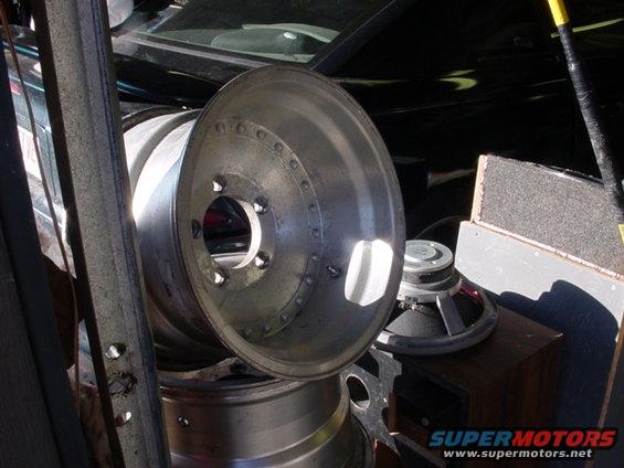 stack of car rims and speakers in a garage