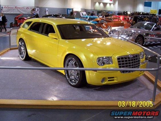 Yellow station wagon with chrome wheels and a prominent grille
