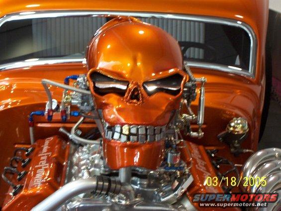 Orange hot rod engine with a chrome skull cover and visible plumbing. Date stamp reads 03/18/2005