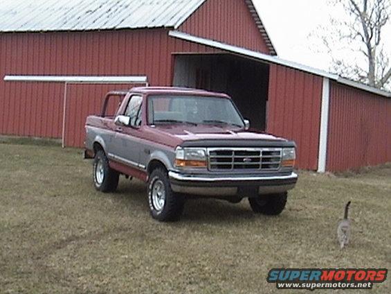 1994 Ford Bronco parked in front of a red barn