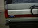 1990 Ford Bronco - Rear view of a 1990 Ford Bronco showing the tailgate with Ford emblem and stripe.